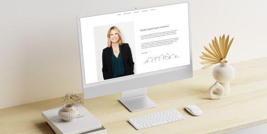 Desktop mockup of Marnie Quarry's website on a desk in natural light setting.
